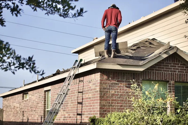 Professional roofer working on a residential roof in Brownfields